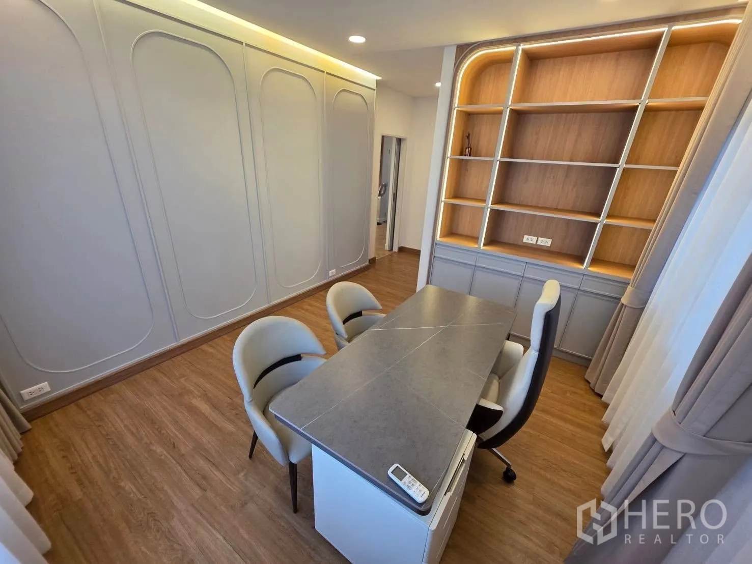 Detached House for rent or sale in Bang Phli, Samut Prakan - Home office with desk, chairs and illuminated built-in shelving.