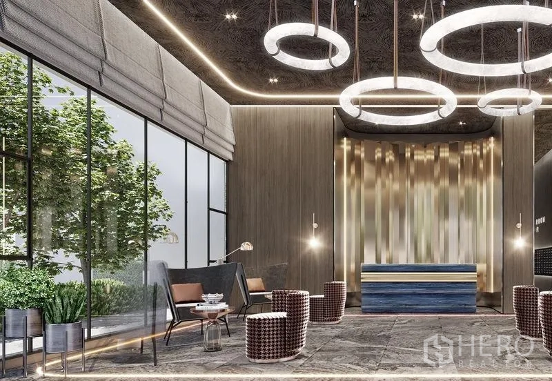 Condominium for sale in Khlong Toei, Bangkok - Design-led condominium lobby with ring chandeliers, a reception desk, and floor-to-ceiling windows opening to greenery.