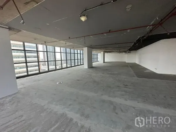 Office Space for rent - Large unfurnished office floor with exposed ceiling and wrap-around glazing offering city views.