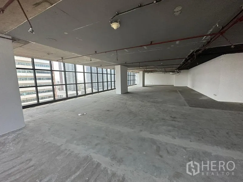 Office Space for rent - Large unfurnished office floor with exposed ceiling and wrap-around glazing offering city views.