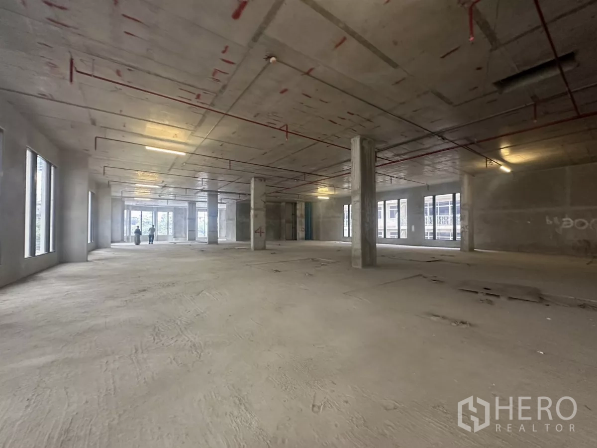 零售空间 出租在Watthana, Bangkok - 大面积开放式商铺层，红色顶管与结构柱，布局灵活。