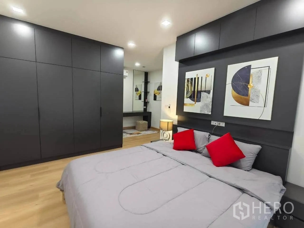 Detached House for rent in Bang Phli, Samut Prakan - Bedroom with gray built-in wardrobes and a bed with red cushions.