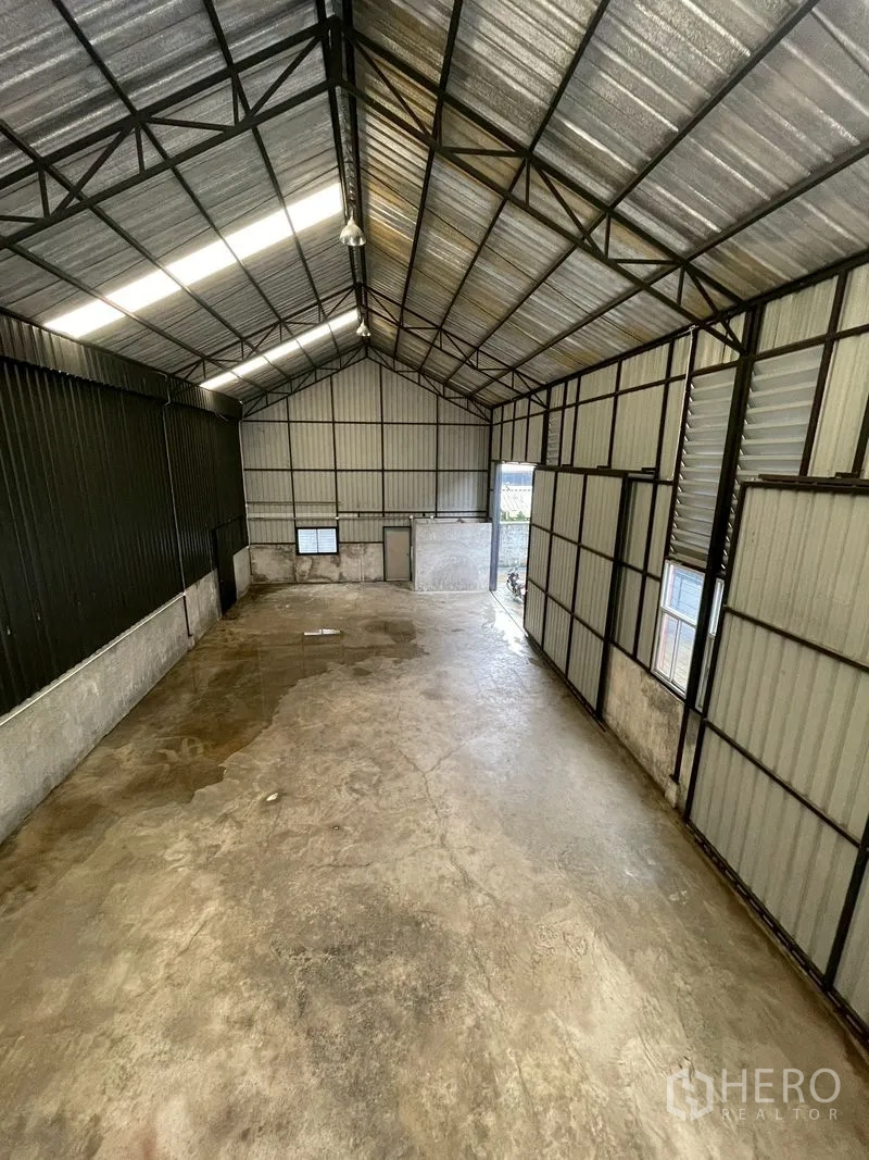Warehouse for rent in Lat Phrao, Bangkok - Open warehouse hall with steel truss roof, ventilation louvers, and concrete floor.