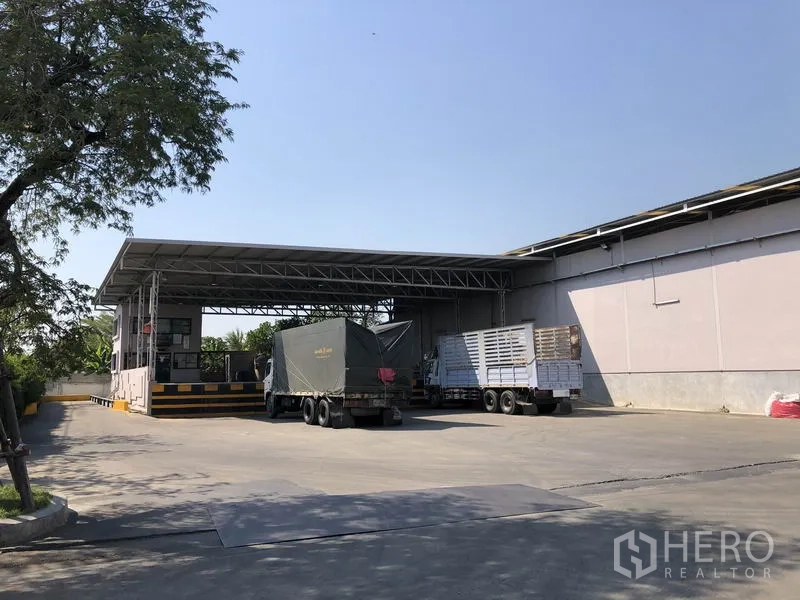 Warehouse for rent in Bang Bua Thong, Nonthaburi - Covered loading dock with weighbridge and cargo trucks beside the warehouse.