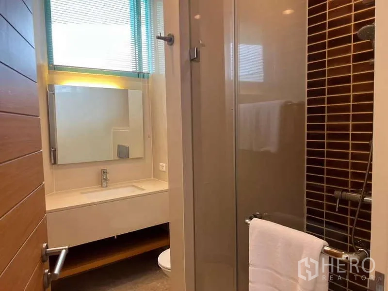 Condominium for rent in Bang Kho Laem, Bangkok - Guest bathroom with glass shower and illuminated mirror.