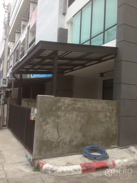 สำนักงานที่บ้าน ให้เช่าในBang Phli, Samut Prakan - มุมมองด้านข้างของอาคารพาณิชย์แบบทาวน์โฮม มีกันสาดและกำแพงรอบ