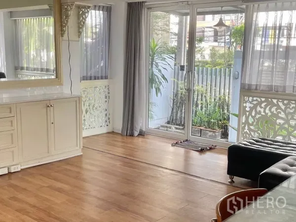 Home Office for rent or sale in Suan Luang, Bangkok - Living area with large sliding glass doors opening to a small garden patio.