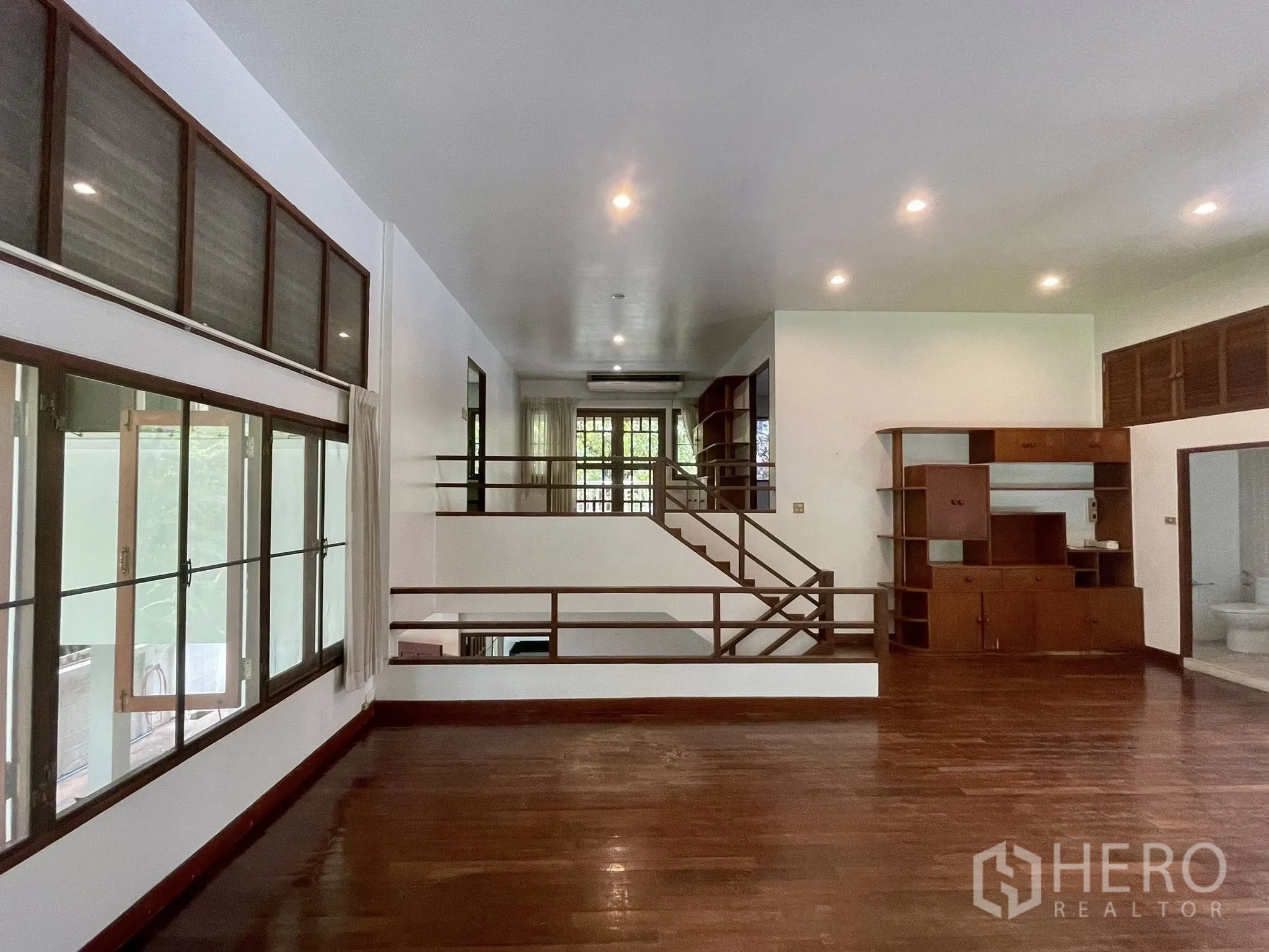 บ้านเดี่ยว for rent in Pathum Wan, Bangkok - ห้องนั่งเล่นแบบสเต็ป พื้นไม้ บันได และไฟดาวน์ไลท์