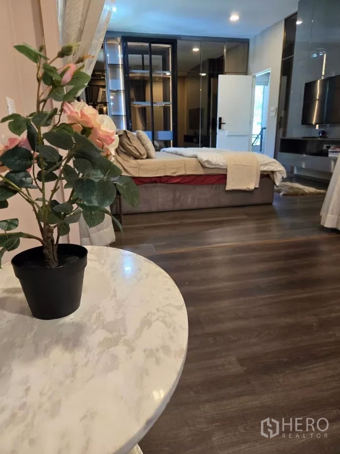 Detached House for rent or sale in Bang Phli, Samut Prakan - Bedroom seating nook with marble side table and potted flowers on wood flooring.