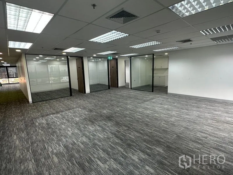Office Space for rent in Khlong Toei, Bangkok - Open-plan area with multiple glass meeting rooms and suspended ceiling lights.