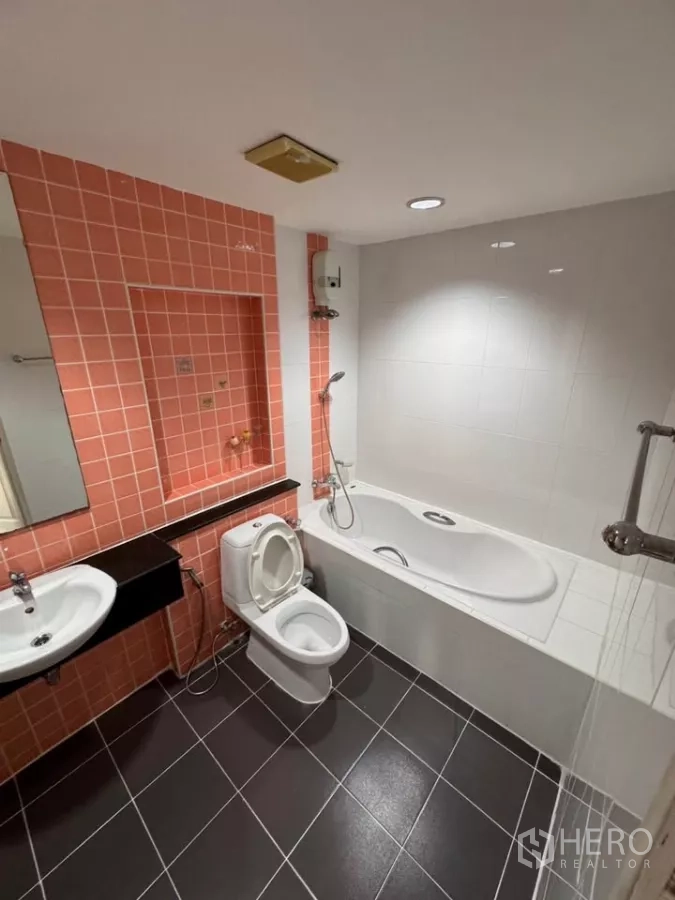 Townhouse for rent in Bang Kho Laem, Bangkok - Bathroom with coral tiles, bathtub with shower, black tile floor and vanity sinks.