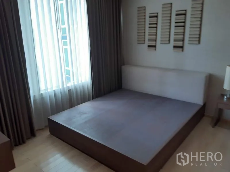 คอนโด ให้เช่าในKhlong Toei, Bangkok - ห้องนอนอบอุ่นพร้อมฐานเตียง หน้าต่างบานใหญ่ และผ้าม่านทึบแสง