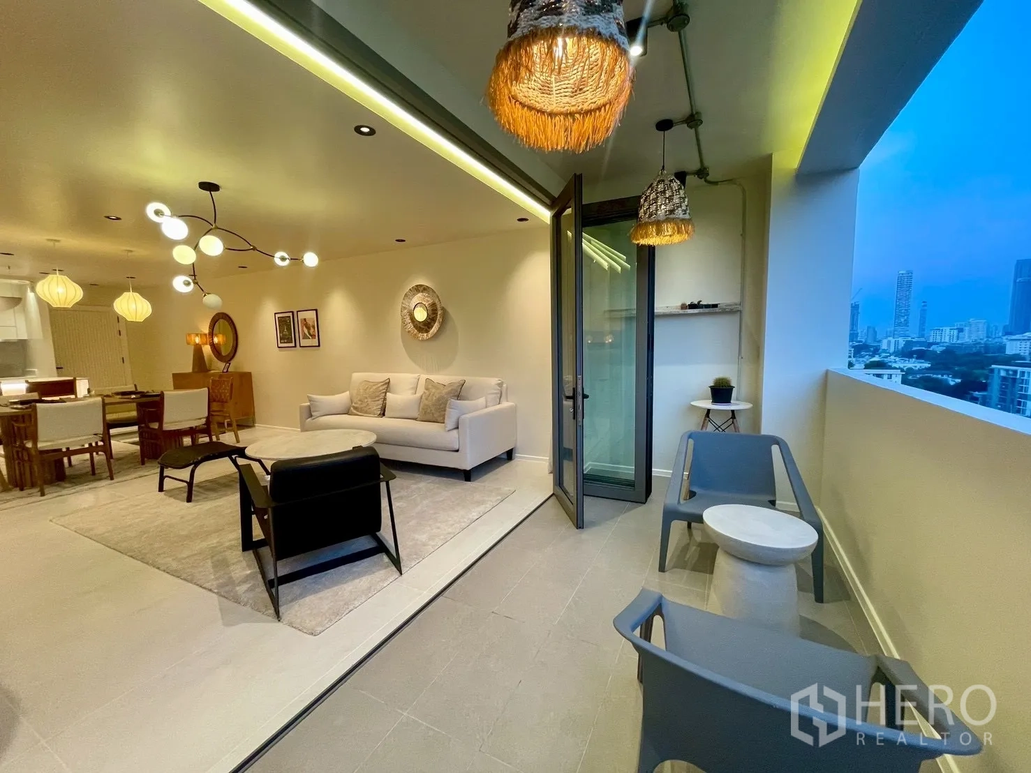 Condominium for sale in Watthana, Bangkok - Covered balcony with seating opening to the living room via folding doors.
