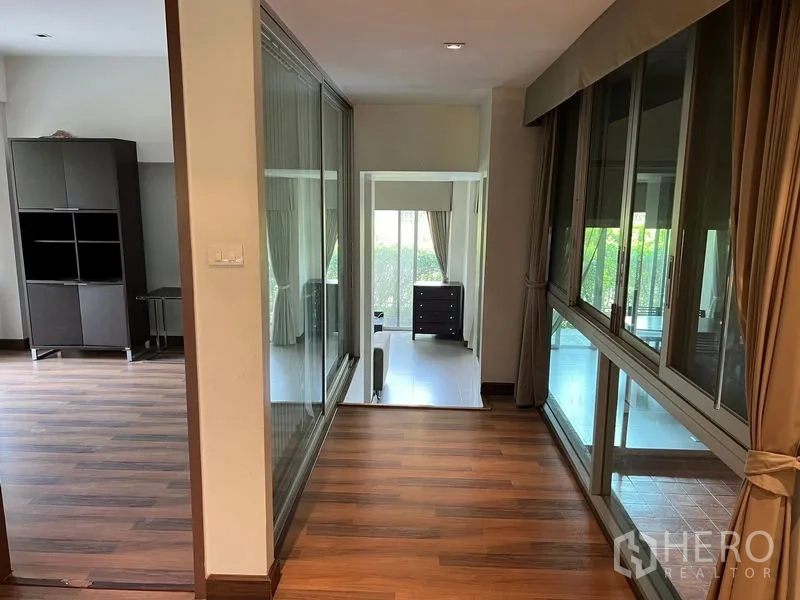 อพาร์ทเมนท์ ให้เช่าในWatthana, Bangkok - โถงทางเดินพื้นไม้พร้อมผนังกระจกภายในเชื่อมสู่พื้นที่นั่งเล่น