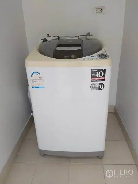 公寓 出租在Watthana, Bangkok - 室内上开式洗衣机，位于小型瓷砖洗衣区。