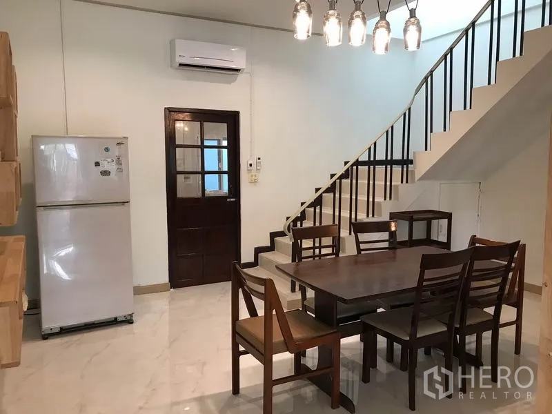 ทาวน์เฮาส์ ให้เช่าหรือขายในPhra Khanong, Bangkok - ส่วนทานอาหาร โต๊ะไม้ โคมไฟแขวน ตู้เย็น และบันไดราวเหล็ก
