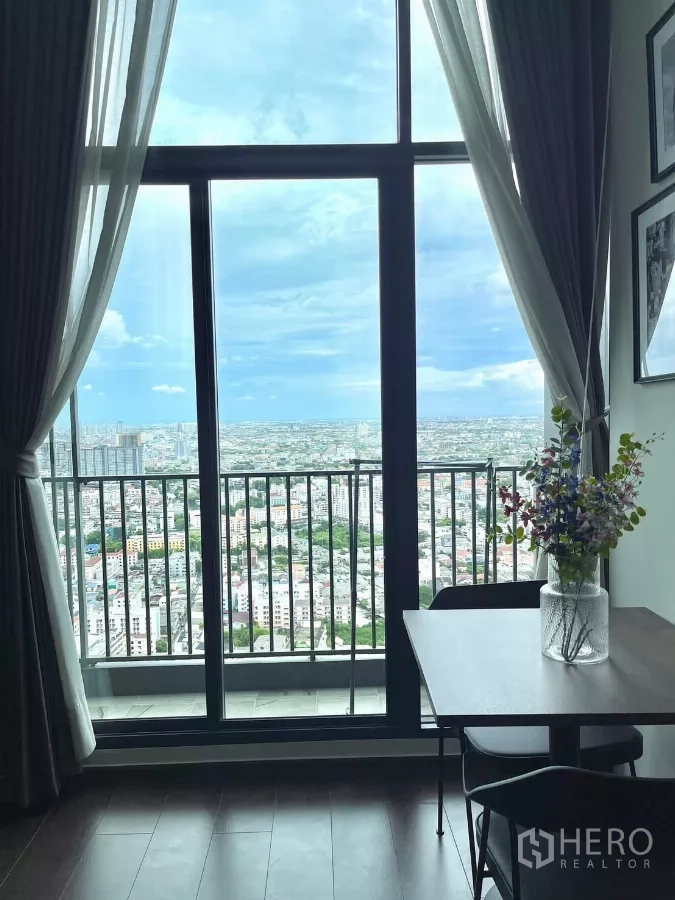 Condominium for rent in Watthana, Bangkok - Sliding glass door to the balcony framing a sweeping Bangkok skyline.