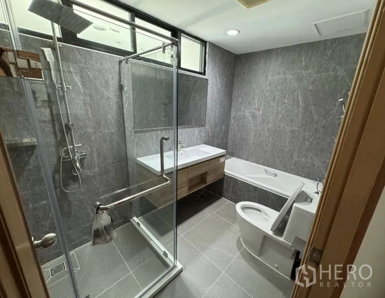 คอนโด ให้เช่า - ห้องน้ำสมัยใหม่ พร้อมตู้กระจกกั้นอาบน้ำ อ่างอาบน้ำ และอ่างล้างหน้าแบบลอย