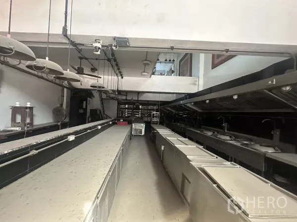 店屋 出租在Bang Na, Bangkok - 厨房反向视角，双烹饪线、洗槽、储物与排烟罩一应俱全。