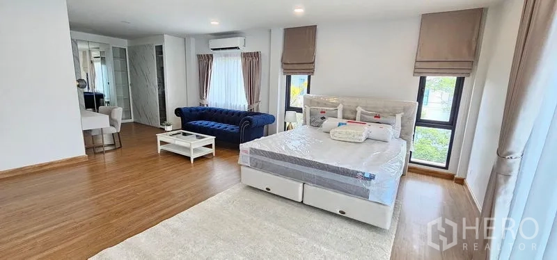 Detached House for rent - Spacious master bedroom with king bed, blue sofa, wood flooring, bright windows and a dressing area.