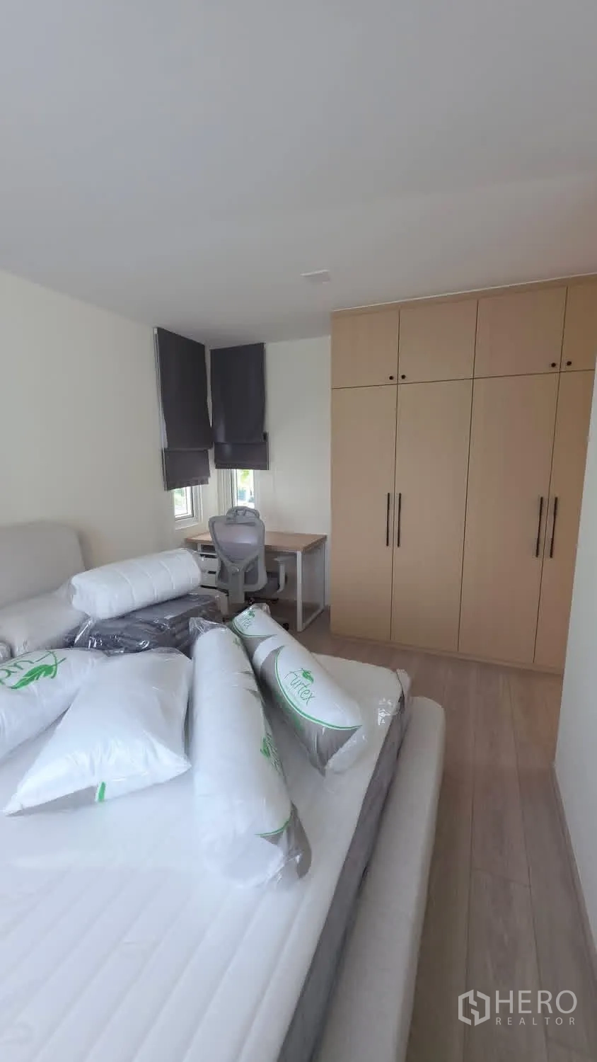Detached House for rent in Bang Phli, Samut Prakan - Bedroom with bed frame, built-in wardrobe wall, and work desk.