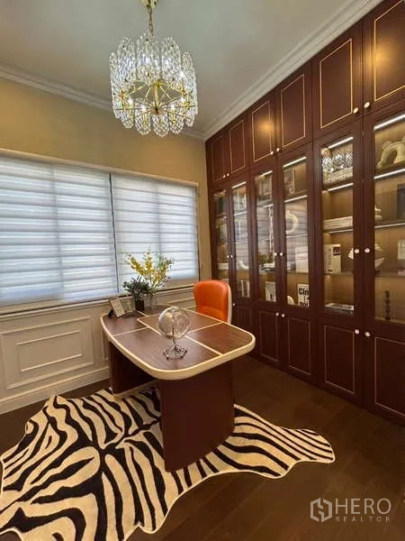 Detached House for sale in Bang Kapi, Bangkok - Home library with built-in glass cabinets, zebra rug and crystal chandelier.