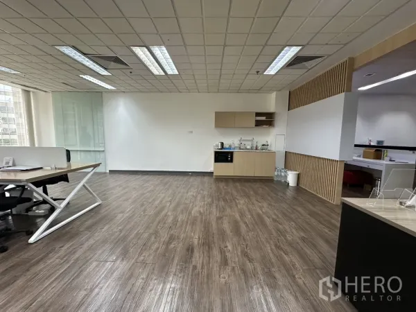 Office Space for rent - Open pantry and lounge zone with wood flooring and light wood built-in cabinets.