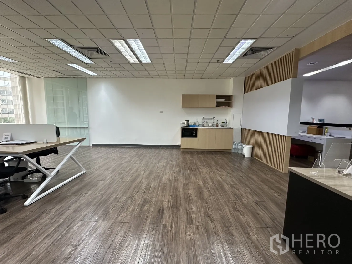 Office Space for rent - Open pantry and lounge zone with wood flooring and light wood built-in cabinets.