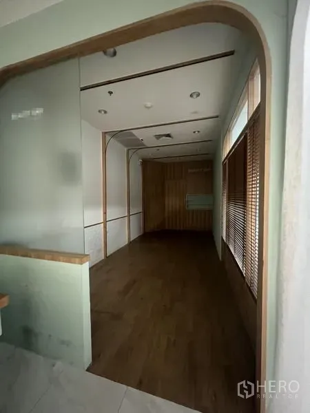 พื้นที่ขายปลีก ให้เช่าในWatthana, Bangkok - พื้นที่ค้าปลีกขนาดกะทัดรัด พื้นไม้ ลายโค้งที่ผนัง ไฟดาวน์ไลท์ และผนังไม้ตกแต่งด้านท้ายห้อง.