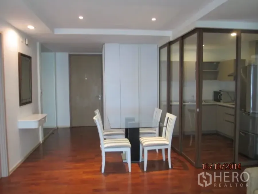 คอนโด ให้เช่าหรือขายในKhlong Toei, Bangkok - พื้นที่รับประทานอาหาร โต๊ะกระจก เก้าอี้สีขาว ข้างครัวกั้นกระจก พื้นไม้และไฟฝังเพดาน