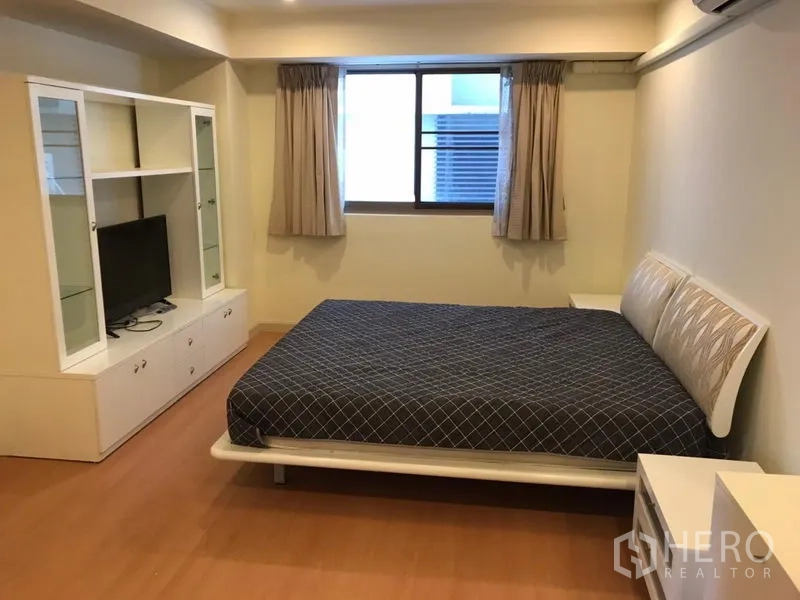 Condominium for rent in Watthana, Bangkok - Cozy bedroom with double bed, built-in TV unit and window.