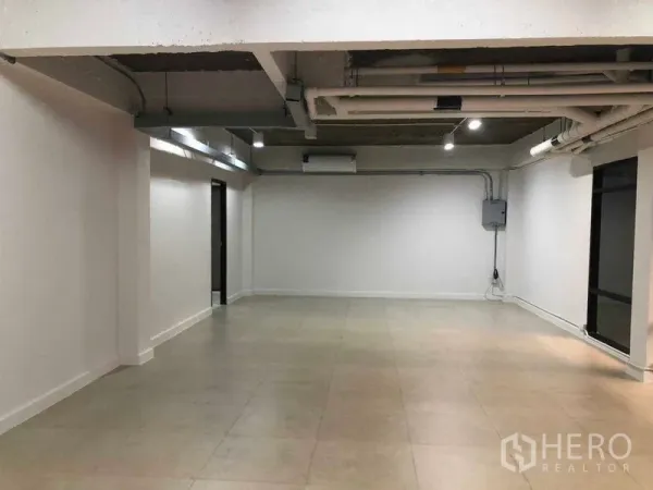 办公空间 出租在Phaya Thai, Bangkok - 65平米开放式办公室，外露管线天花、白色墙面与瓷砖地面。