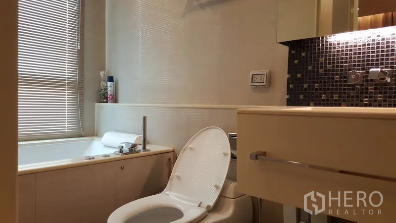 คอนโด ให้เช่าในRatchathewi, Bangkok - ห้องน้ำพร้อมอ่างอาบน้ำ เคาน์เตอร์อ่างล้างหน้า และหน้าต่างพร้อมมู่ลี่ โทนสีอ่อน