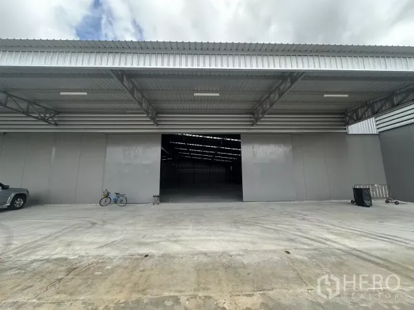 Warehouse for rent in Khlong Toei, Bangkok - Close view of the loading area with deep metal canopy, wide entrance and concrete apron.