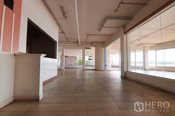 零售空间 出租在Yan Nawa, Bangkok - 宽敞零售大厅，瓷砖地、承重柱与外露管线，配大型展示玻璃墙。