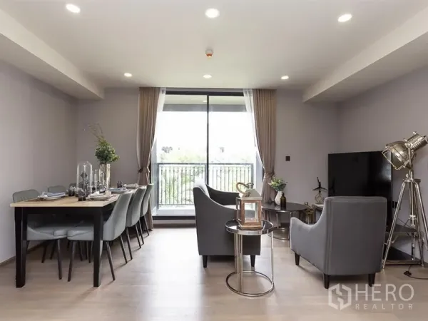 คอนโด ให้เช่าในPathum Wan, Bangkok - มุมนั่งเล่นและรับประทานอาหารสว่างโปร่ง พร้อมประตูกระจกบานเลื่อนออกสู่ระเบียงเห็นวิวต้นไม้