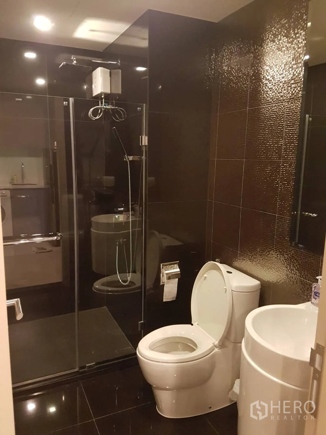 คอนโด ให้เช่าในKhlong Toei, Bangkok - ห้องน้ำสมัยใหม่พร้อมฝักบัวกระจก กรุกระเบื้องสีเข้มและสุขภัณฑ์สีขาว