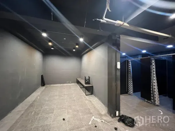 โชว์รูม ให้เช่าในMueang Samut Prakan, Samut Prakan - ห้องภายในโทนเข้ม ไฟสปอตไลท์ ม้านั่ง และพื้นที่เปลี่ยนชุดมีผ้าม่าน