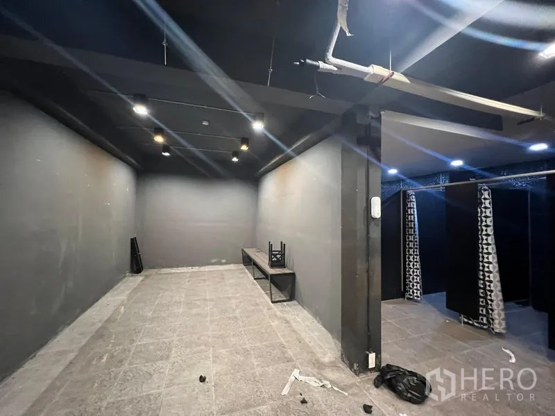 โชว์รูม ให้เช่าในMueang Samut Prakan, Samut Prakan - ห้องภายในโทนเข้ม ไฟสปอตไลท์ ม้านั่ง และพื้นที่เปลี่ยนชุดมีผ้าม่าน