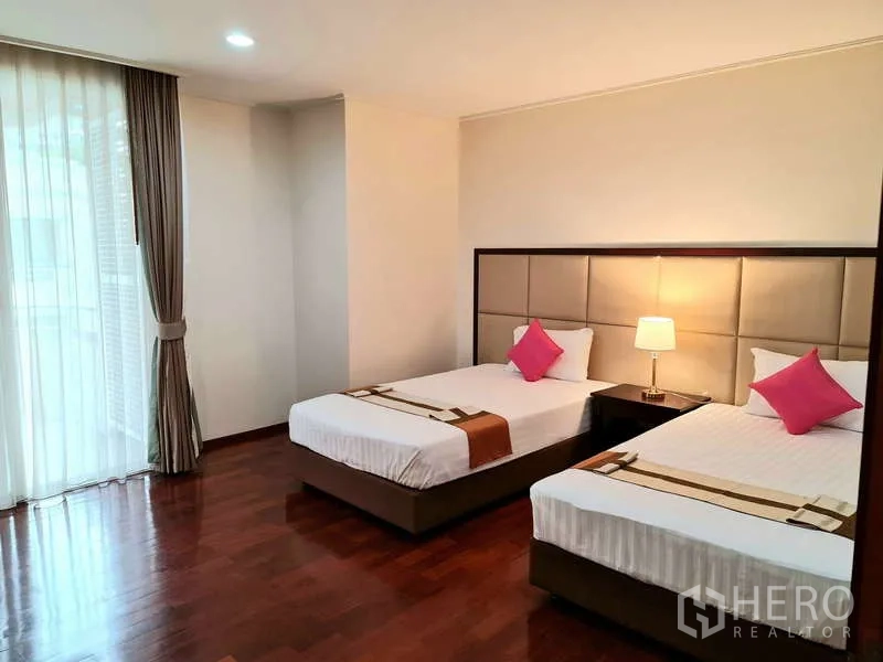 อพาร์ทเมนท์ ให้เช่า - ห้องนอนเตียงคู่ พื้นไม้ และม่านโปร่งแสง