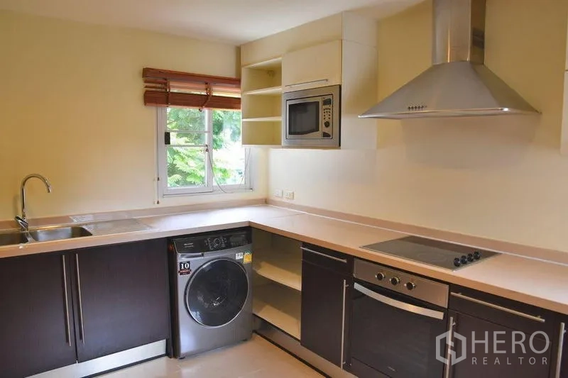 房间 出租在Sathon, Bangkok - U形厨房，带窗户，内置烤箱、炉灶、油烟机和洗衣机。