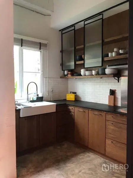 ทาวน์เฮาส์ ขายในWang Thonglang, Bangkok - ครัวรูปตัว U ซิงก์ฟาร์มเฮาส์ ตู้ไม้ หน้าต่าง และผนังตกแต่งกระเบื้องซับเวย์สีขาว