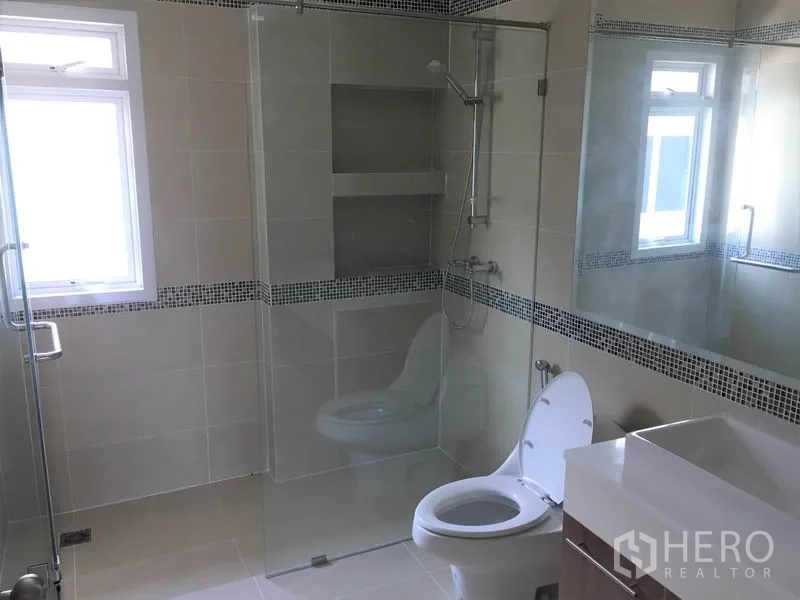 Detached House for rent in Saphan Sung, Bangkok - Contemporary bathroom with glass-enclosed shower, wall niche and vanity basin.