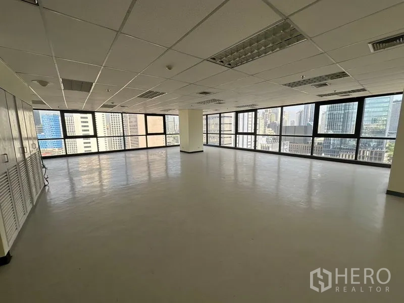 办公空间 出租在Bang Rak, Bangkok - 开放式办公内景，网格吊顶与空调出风口，充足自然采光的整面窗。