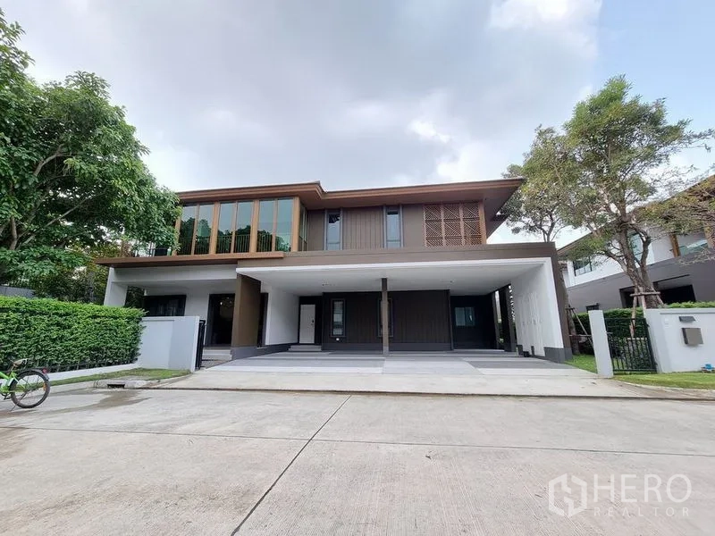 Detached House for rent in Prawet, Bangkok - Contemporary two‑storey facade with expansive covered driveway and parking.