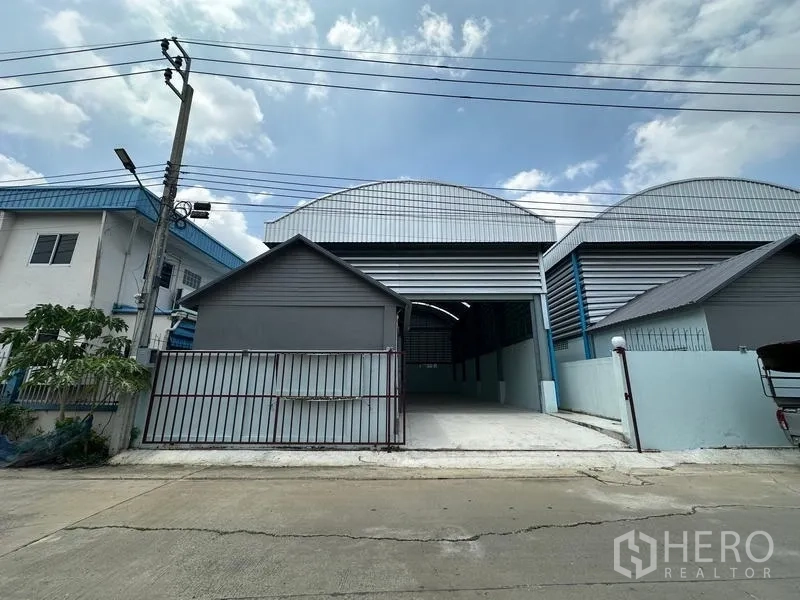 工厂 出租在Pak Kret, Nonthaburi - 正立面，超高卷帘门与混凝土车道通向厂房