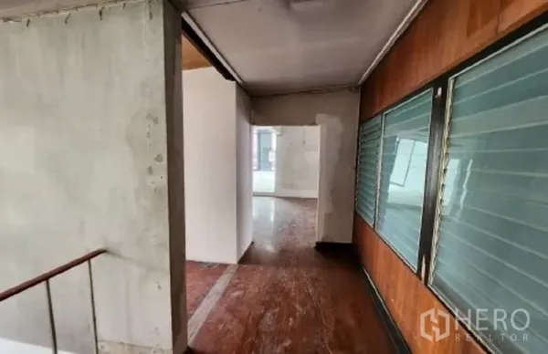 พื้นที่ขายปลีก ให้เช่าในWatthana, Bangkok - โถงทางเดินผนังคอนกรีต พื้นไม้ และหน้าต่างบานเกล็ดสู่ห้องสว่าง