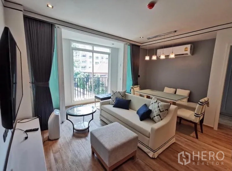 คอนโด ให้เช่าในSathon, Bangkok - ห้องรับแขกสว่างด้วยประตูสูงจรดเพดาน เปิดออกสู่ระเบียงวิวต้นไม้