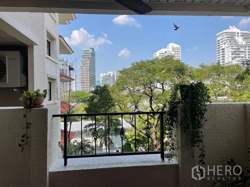 Condominium for rent in Watthana, Bangkok - Balcony view over treetops toward the Ekkamai skyline and high-rise buildings.