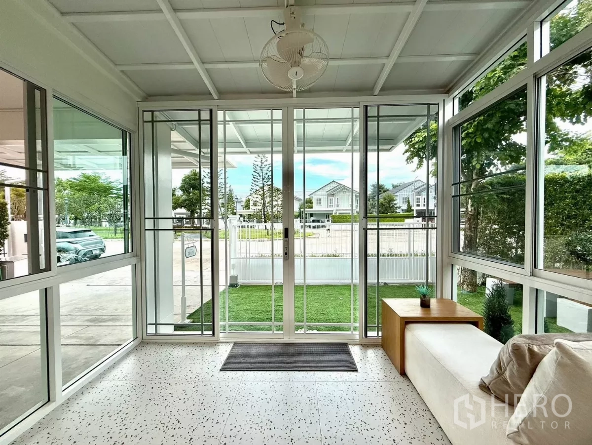 Detached House for rent in Bang Phli, Samut Prakan - Bright glass sunroom overlooking front lawn and community street.